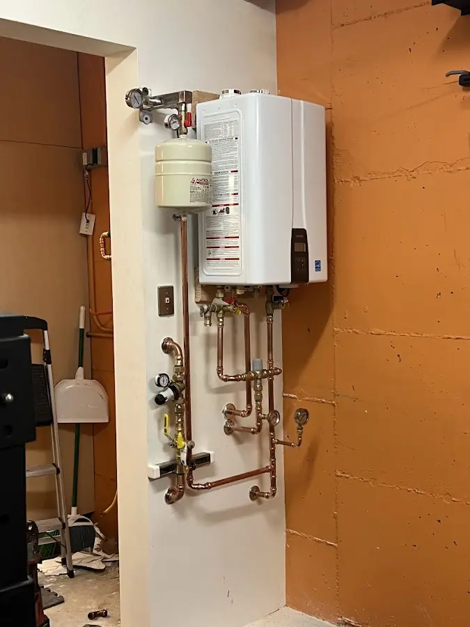 Plumbing technician inspecting water heater connections in Kodiak